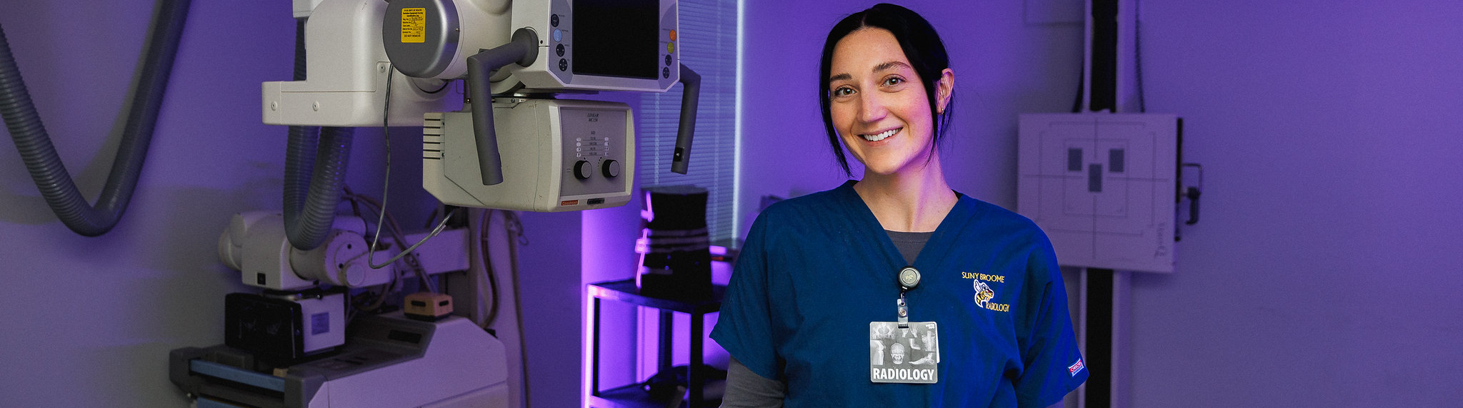 Student posing in front of medical equipment