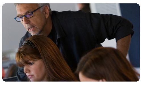 A picture of a faculty member leaning over a computer monitor.