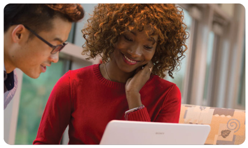 A student and advisor viewing a laptop.